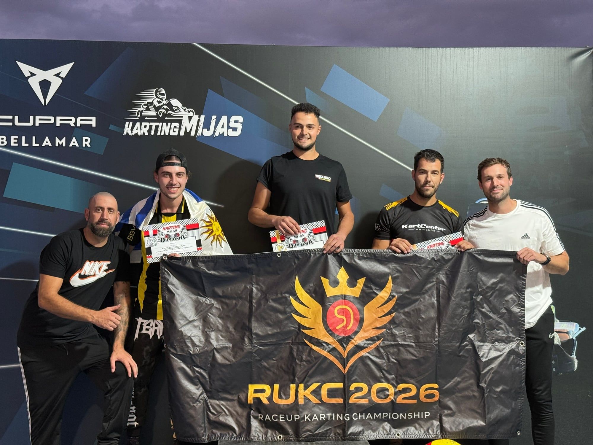 Podio de la R1 con la bandera de RUKC 2026 en Karting Mijas