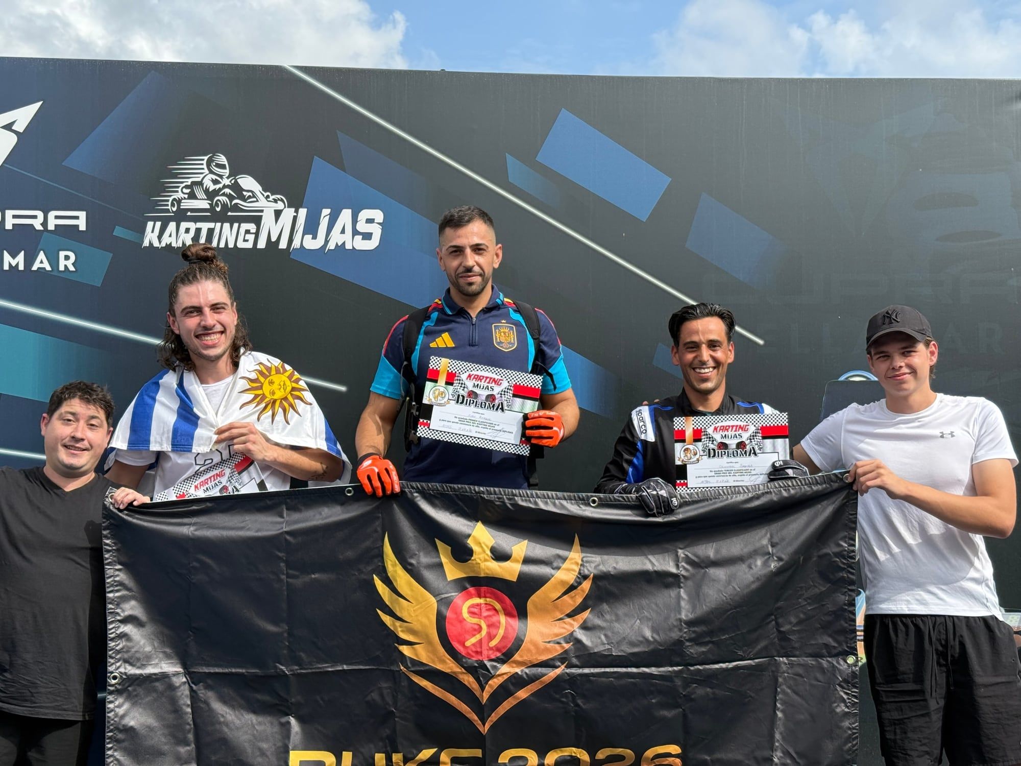 Podio de la R1 de la Temporada 2 en Karting Mijas con la bandera de RUKC 2026